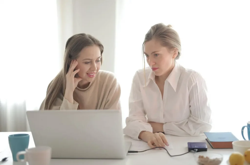 2 female office coworkers at a laptop