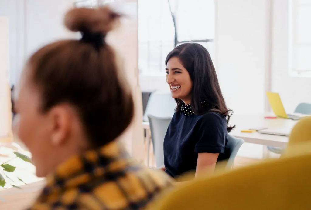 two happy office workers laughing